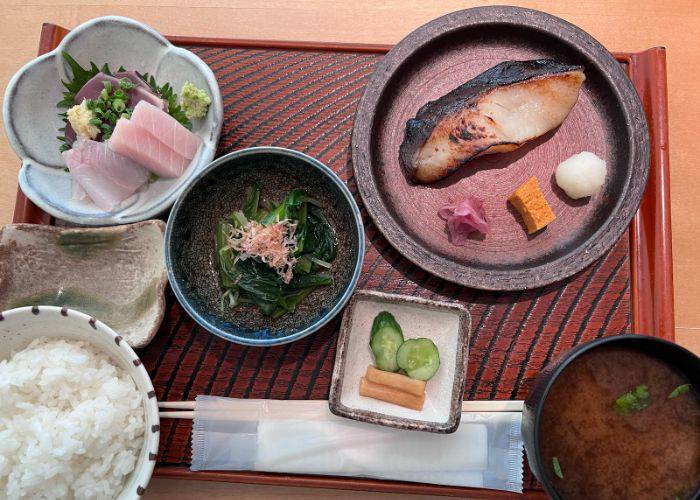 A kappo-style meal at Rintaro in the Miyagi Prefecture, featuring salmon, rice, sashimi and pickled vegetables.